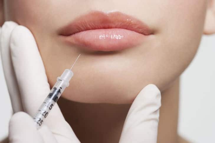 close up of woman receiving botox injection in lips royalty free image 1607550026